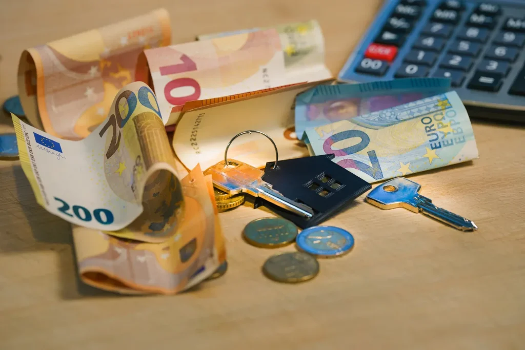 Calcolatrice, denaro e chiavi per valutare le spese domestiche